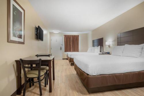 ein Hotelzimmer mit großem Bett und Schreibtisch in der Unterkunft SureStay Studio by Best Western Gonzales in Gonzales