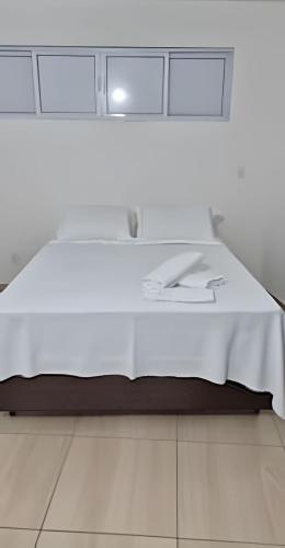 a white bed with white sheets on top of it at Apartamento brisa do oceano in Natal