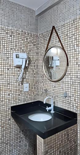 a bathroom with a sink and a mirror at Apartamento brisa do oceano in Natal