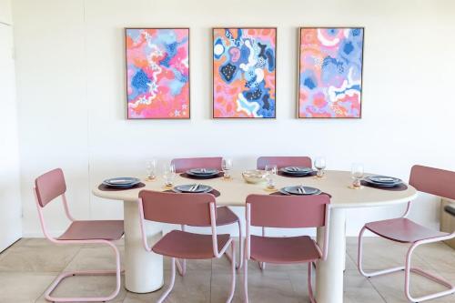 een eetkamer met een witte tafel en stoelen bij Beachfront Canvas - Ocean Views Pool Gym in Mudjimba