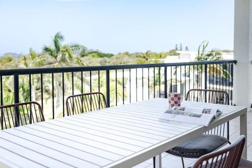 a white table and chairs on a balcony at Beachfront Canvas - Ocean Views Pool Gym in Mudjimba