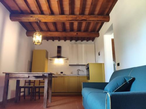 a living room with a table and a kitchen at Agriturismo Collina degli Ulivi in Sarteano