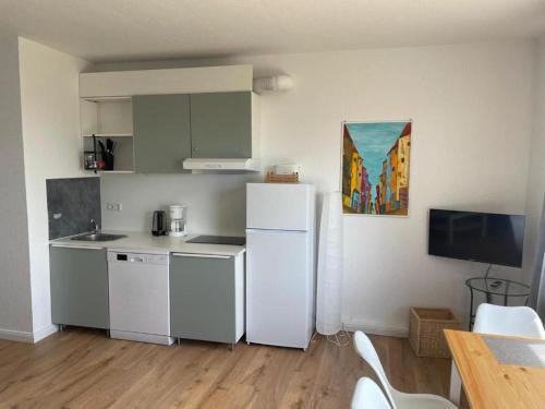 a kitchen with a white refrigerator and a table at Ferienwohnung-Neuwerk in Baltrum