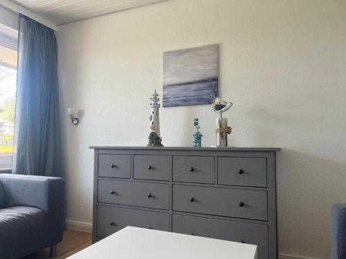 a dresser in a living room with a blue couch at Ferienwohnung-Helgoland in Baltrum