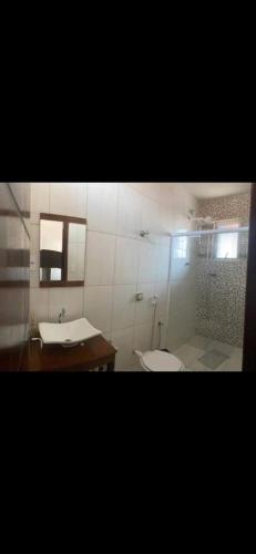 a bathroom with a shower and a toilet and a sink at Espaço Clarabella in Serra Negra