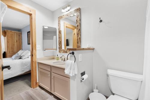 a bathroom with a sink and a toilet and a mirror at Whispering Red Pine Paradise in Park City