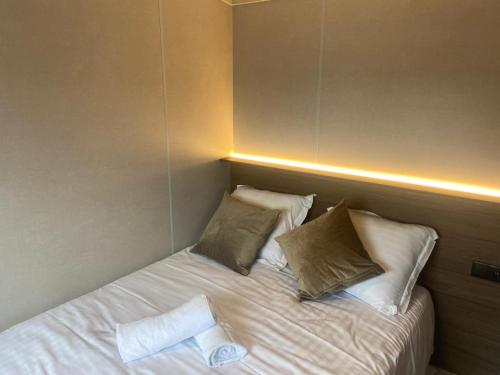 a bed with two pillows and a towel on it at Chalet Tiny & Campagne in Onnion