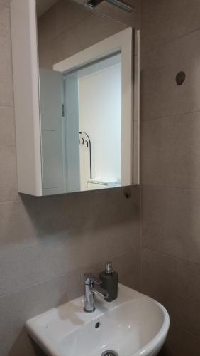 a bathroom with a white sink and a mirror at Apartman studio KOPS in Vranješ