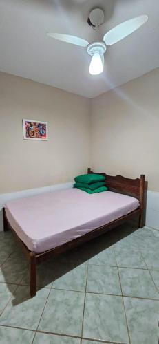 a bed in a room with a ceiling fan at Apartamento 5 minutos a pé da praia in Guarapari