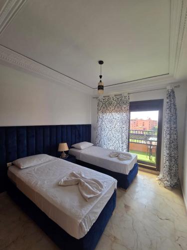 a bedroom with two beds and a large window at andalous 4 in Marrakesh
