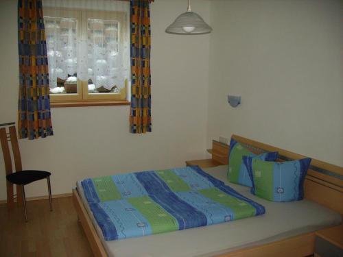 1 dormitorio con 1 cama con sábanas azules y verdes en Appartement Lea, en Umhausen