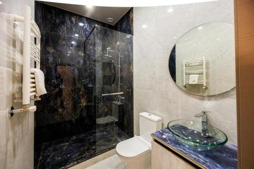 a bathroom with a sink and a toilet and a mirror at New York Hotel Yerevan in Yerevan