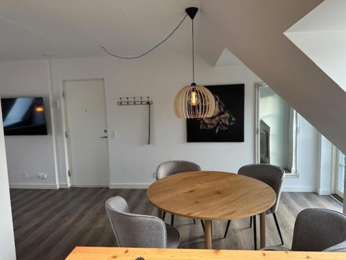 a dining room with a wooden table and chairs at 11F 2 TV Højbanetorvet in Vejle