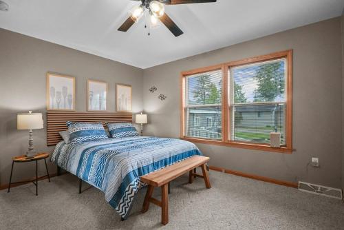 a bedroom with a bed and a ceiling fan at Beach Front Houghton Lake with Game Room in Port Huron