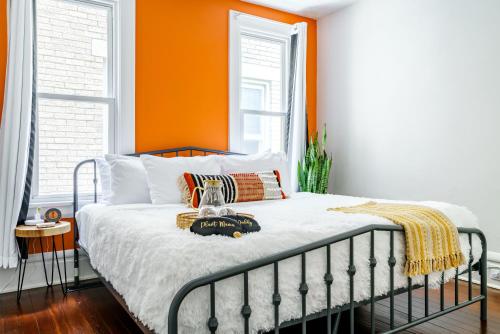 a bed in a room with an orange wall at Prime Location Top Rated Clean Parking Free! in Columbus