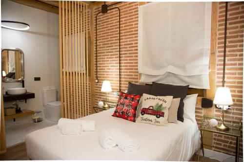 a bedroom with a white bed with pillows on it at El capricho Balcón en la Plaza Mayor Salamanca Collection Luxury in Salamanca