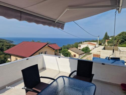 Un balcón con dos sillas y vista al mar. en Apartmani Kruče, en Ulcinj