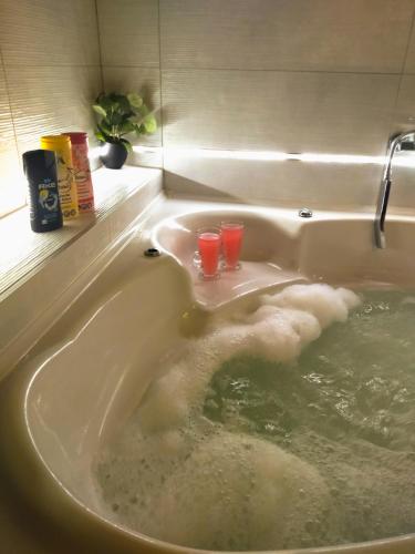 a bath tub with two drinking glasses in it at Apartman Nevena in Subotica