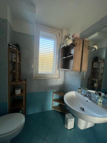 a bathroom with a sink and a toilet and a window at Casa Omero in Sperlonga