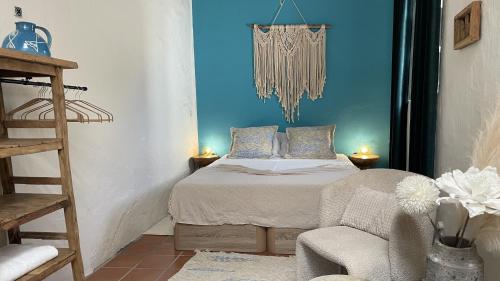 Un pequeño dormitorio con una cama y una silla. en Casa Cueva Soluna, for peace & nature Cabo de Gata, en Níjar