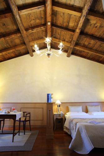 a bedroom with two beds and a table and a chandelier at Isola Di Caprera in Mira