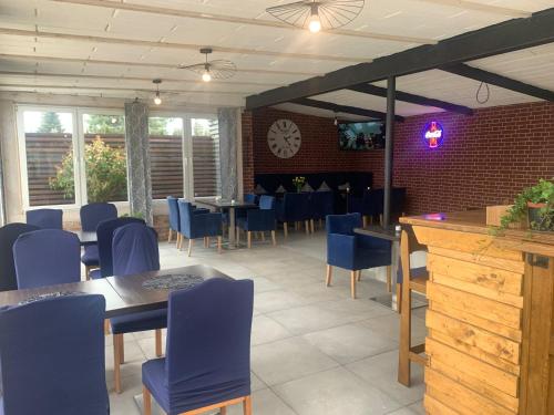 a restaurant with blue chairs and tables and a brick wall at KING Guest Inn in Drawsko Pomorskie
