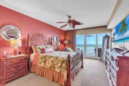 a bedroom with a large bed and a balcony at La Vistana #A503 in St Pete Beach