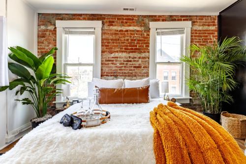 a bedroom with a brick wall and a large bed at Short North Convention Private Parking Pets! in Columbus