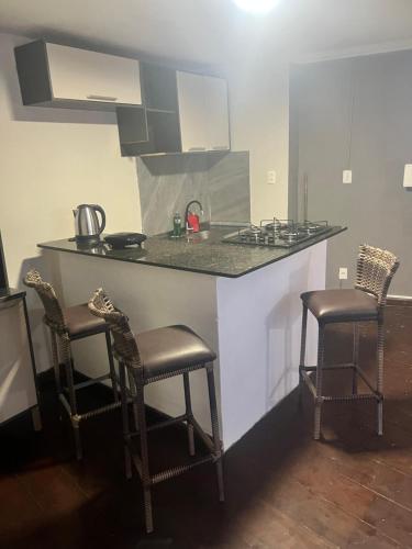a kitchen with a counter with two chairs and a counter top at Flat Serena in Cayru
