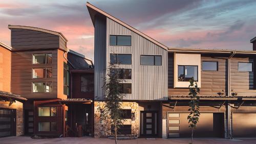 an exterior view of a house with a sunset in the background at Aria Ridge in Steamboat Springs