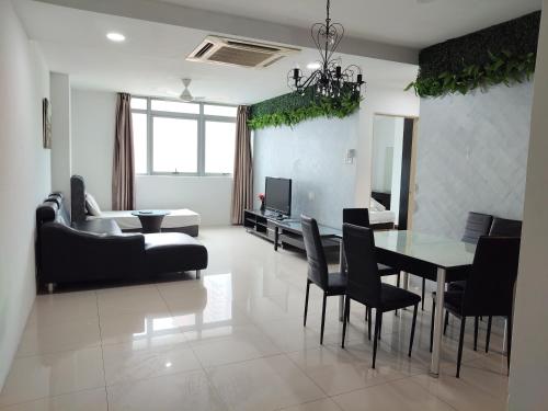 a living room with a table and chairs and a couch at Tarragon Family Suite Apartment in Kuala Lumpur