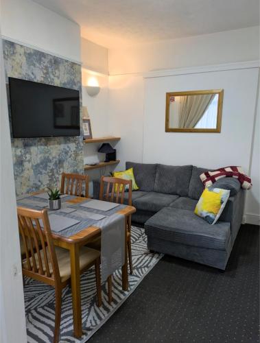 a living room with a table and a couch at Kettering Rooms 4 nights & longer City Vacations Kettering free WiFi for ' Short & Long stays ' Shared bathroom & Shared Kitchen Double room Deals on longer regular stays in Kettering