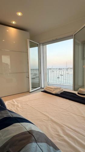 a bedroom with a large window with a view of the ocean at Blue Tao Maison Taormina in Taormina