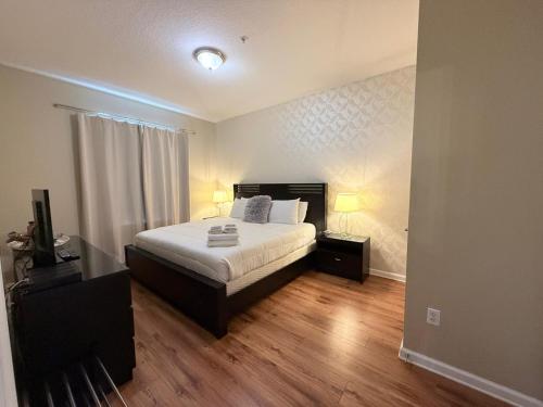 a bedroom with a bed and two night stands with two lamps at 3Br 2Bath Condo Balcony 5min Conv Center 1388ft in Orlando