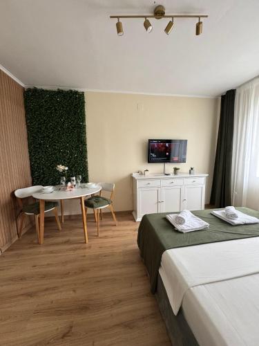ein Hotelzimmer mit zwei Betten und einem Tisch in der Unterkunft Bliss Studio in Slatina