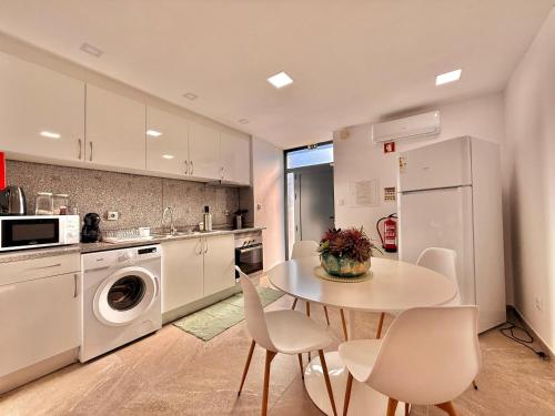 a kitchen with a table and chairs and a white refrigerator at Casa Dos Passadiços Do Mondego in Trinta