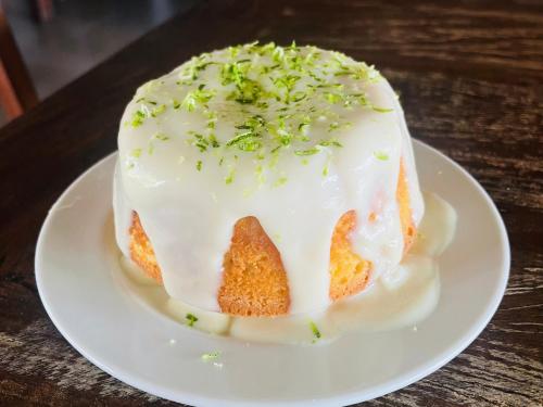 Een taart met witte glazuur en groene hagelslag op een bord. bij POUSADA PONTA DA ASA in Coruripe