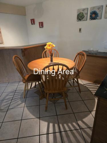 a dining area with a wooden table and chairs at Self Check-In Keyless Private Entry DBL Queen Suite in Mission City