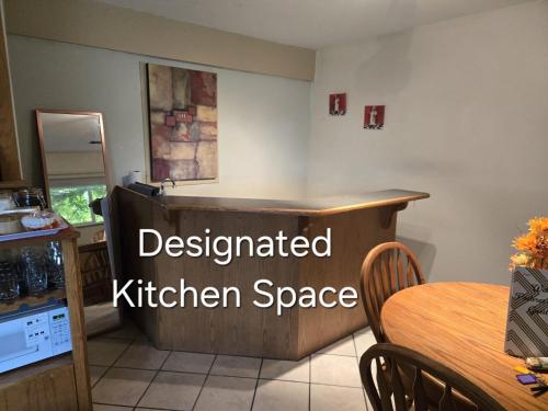 a kitchen with a table and a kitchen space at Pastries&Pillows in Mission City