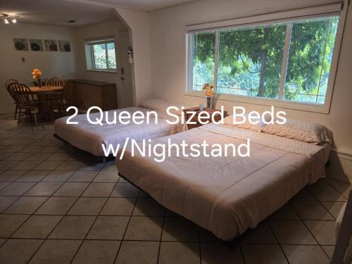 a bedroom with a bed and a table and a window at Self Check-In Keyless Private Entry DBL Queen Suite in Mission City