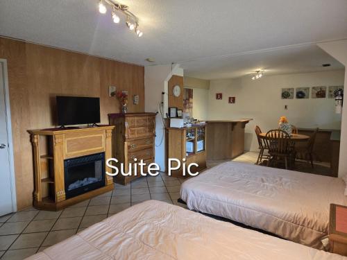 a living room with two beds and a kitchen with a table at Self Check-In Keyless Private Entry DBL Queen Suite in Mission City