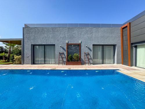 a house with a swimming pool in front of a house at Villa Ramona in Marrakech
