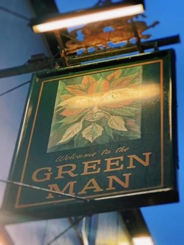 a sign for a green man hanging on a building at The Green Man in Dunchurch