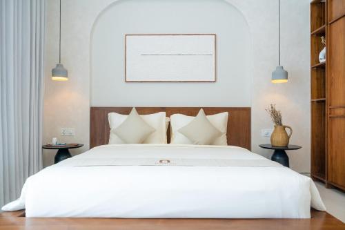 1 Schlafzimmer mit einem weißen Bett und 2 Tischen in der Unterkunft Brand New 2 BR Villa Solina at Bingin Sentosa Villa in Bingin Beach