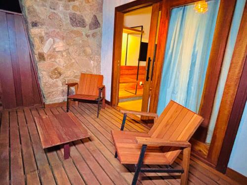 two chairs and a bench in a room with a door at Flor do Umari Eco Hotel e Eventos in Serra de São Bento