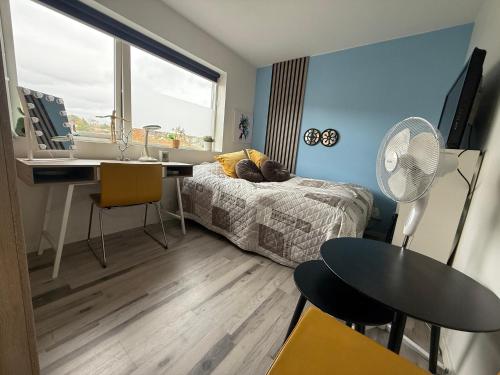 a bedroom with a bed and a desk with a fan at Villa med 4 soverom, sjøutsikt og hage ved lokal badestrand in Bergen