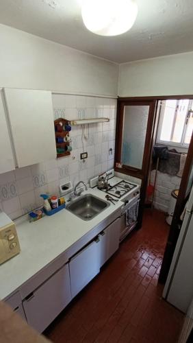 a kitchen with a sink and a stove at Apartamento Gesell in Villa Gesell