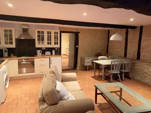 a living room with a couch and a table at Liguand Gites in Saint-Quentin-du-Dropt
