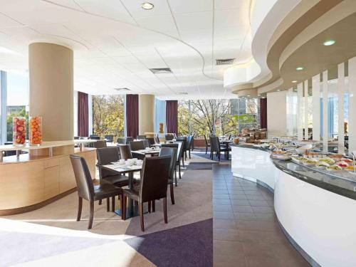 a restaurant with tables and chairs and a buffet at Mercure Warszawa Centrum in Warsaw