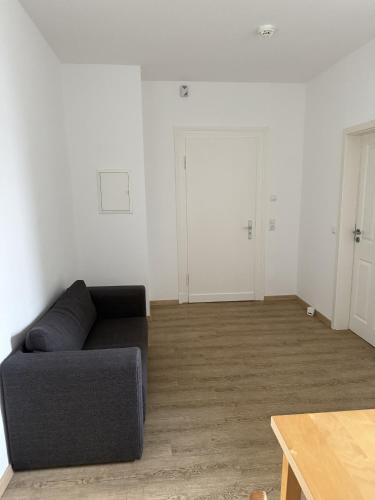 a living room with a black couch and white walls at Wupper Apartments Vogel in Erbschlö